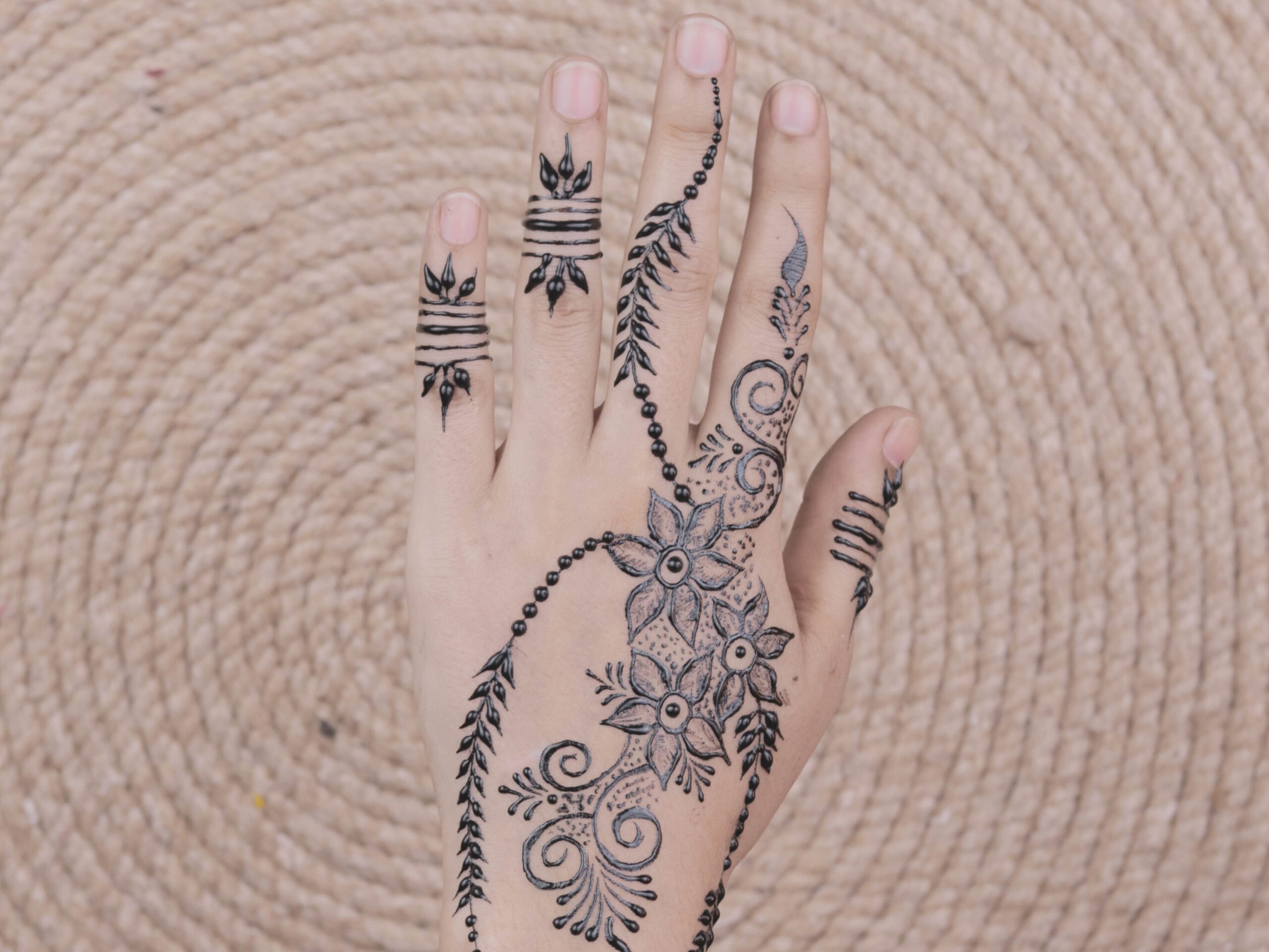 Une main ornée de motifs de henné traditionnels pour les mariages marocains.