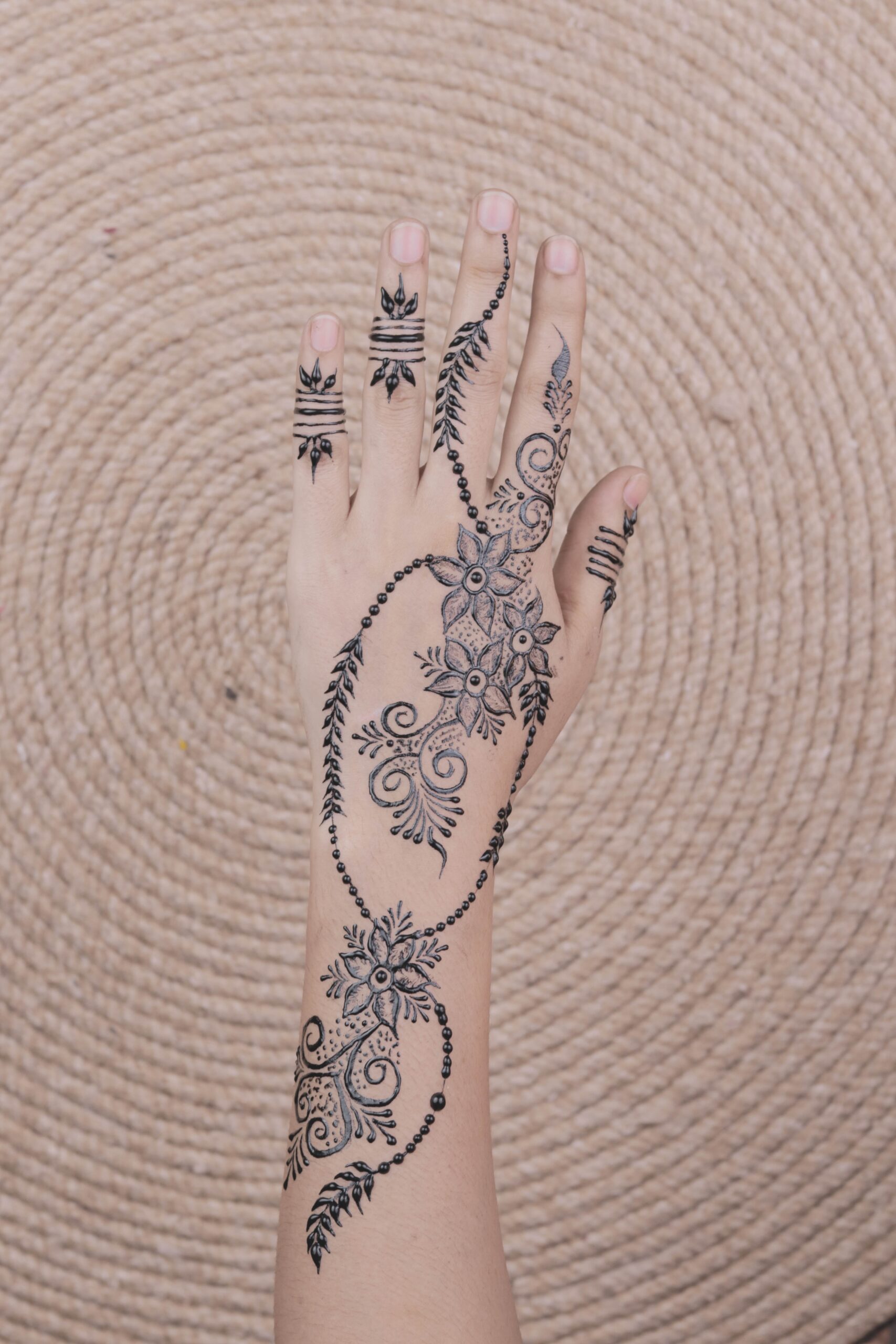 Une main ornée de motifs de henné traditionnels pour les mariages marocains. 